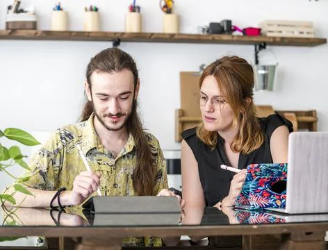 Graphic designers using tablets and working together in workplace Stock Photos