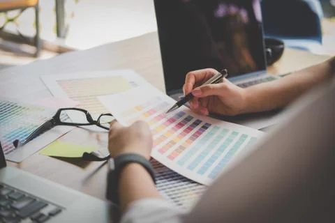 Graphic or interior designer choosing color from swatch sample or catalogue p Stock Photos