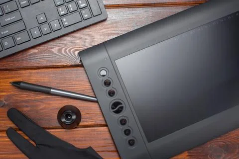 Graphic tablet, digital tablet and special pen, glove and keyboard on a woode Foto stock