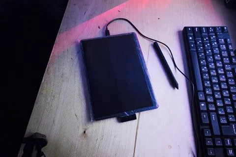 Graphic tablet on the table with bright red and blue lights Foto stock