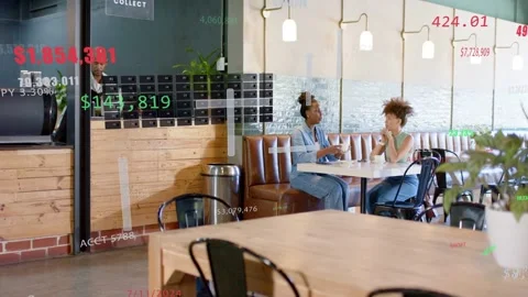 Graphics appearing, two women discussing notebook for data review while barista Stock Footage 333078095