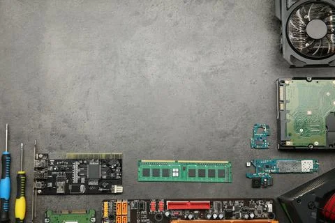 Graphics card and other computer hardware on grey textured table, flat lay... Stock Photos