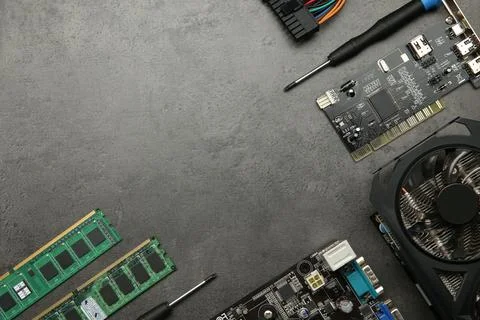 Graphics card and other computer hardware on grey textured table, flat lay... Stock Photos
