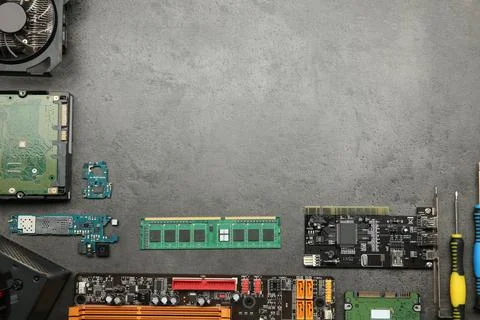 Graphics card and other computer hardware on grey textured table, flat lay... Stock Photos