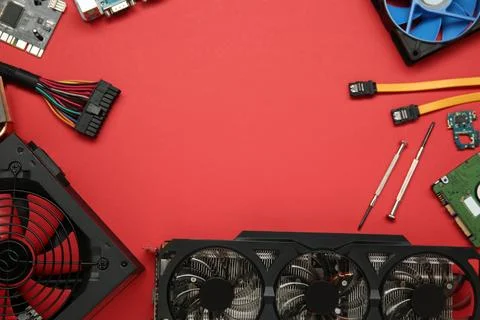 Graphics card and other computer hardware on red background, flat lay. Spac.. Stock Photos