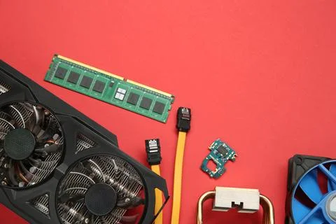 Graphics card and other computer hardware on red background, flat lay. Spac.. Stock Photos