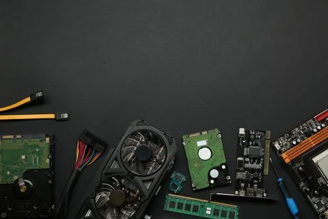 Graphics card and other computer hardware on black background, flat lay. Sp.. Stock Photos
