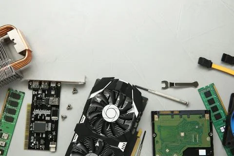 Graphics card and other computer hardware on gray textured background, flat.. Stock Photos