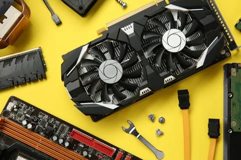 Graphics card and other computer hardware on yellow background, flat lay Stock Photos