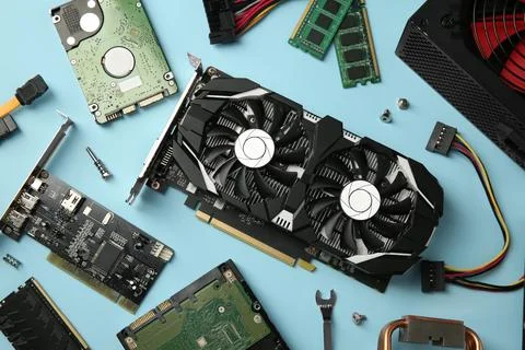 Graphics card and other computer hardware on light blue background, flat lay Stock Photos