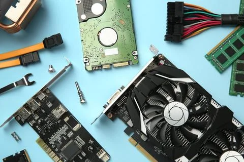 Graphics card and other computer hardware on light blue background, flat lay Stock Photos