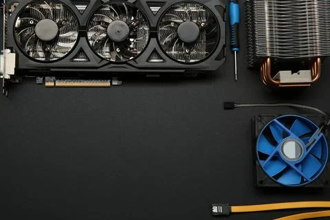 Graphics card and other computer hardware on black background, flat lay. Sp.. Stock Photos