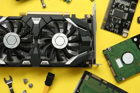 Graphics card and other computer hardware on yellow background, flat lay Stock Photos