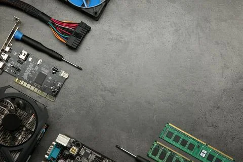 Graphics card and other computer hardware on grey textured table, flat lay... Stock Photos