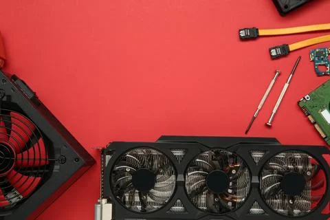 Graphics card and other computer hardware on red background, flat lay. Spac.. Stock Photos