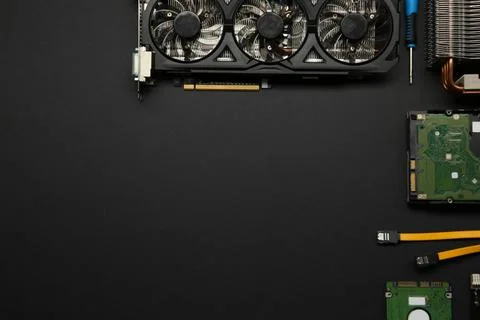Graphics card and other computer hardware on black background, flat lay. Sp.. Stock Photos