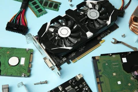 Graphics card and other computer hardware on light blue background, flat lay Stock Photos