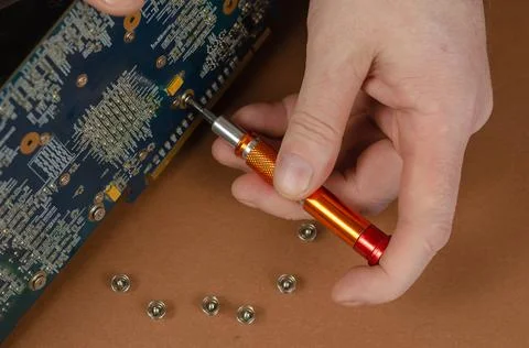 Graphics card on a brown background. Man disassembles computer components, un Foto stock
