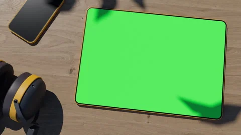 The graphics tablet lies on a wooden table, the video has a green screen with Stock Footage 260940171