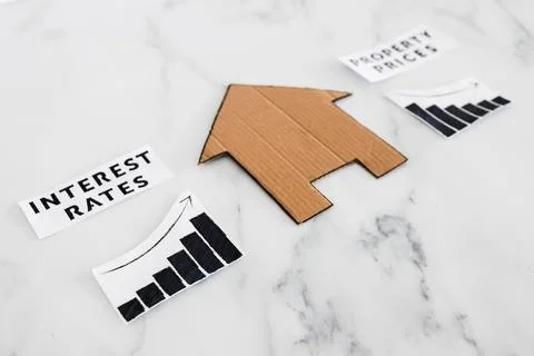 Graphs with interest rates going up and property prices going down next to .. Stock Photos