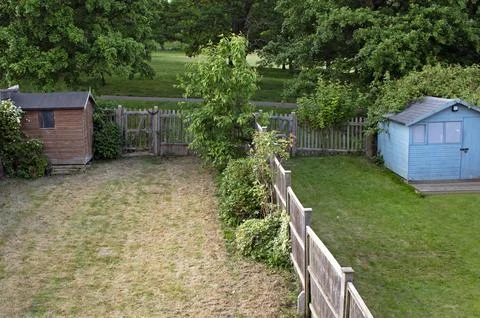 The grass is always greener on the other side - two neighboring gardens, on.. Stock Photos
