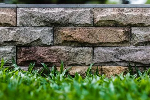 Grass and stone wall background Stock Photos