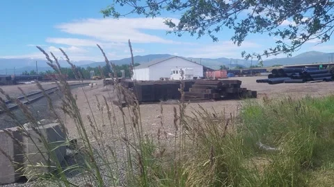 Grass Blowing at Railyards Highway and Mountains in Background, Montana 库存影片 340428314