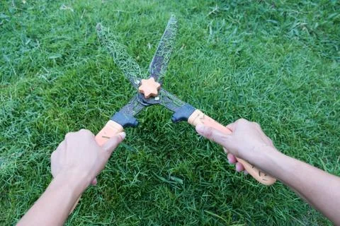 Grass cutting scissors on the grassy background. Stock-Fotos