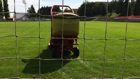 Grass-cutting vehicle cuts grass on football field Stock Footage 95011787