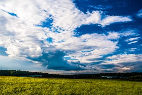 Grass field and dramatic sky at sunset Stock Photos