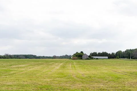 Grass field in spring, with barn in the distant background in Kanata, Ottawa Stock Photos