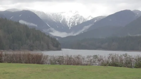 Grass in front of Lake, Mountain Range, Cloudy Sky 스톡 동영상 219529791
