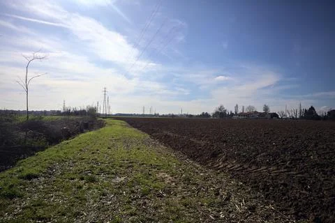 Grass path next to a ploughed field and a trench Stock Photos