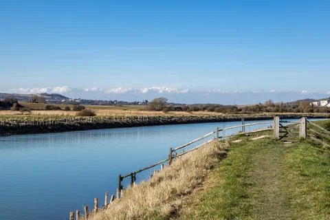 A grass pathway along the River Ouse between Lewes and Southease, with a bl.. Stock Photos
