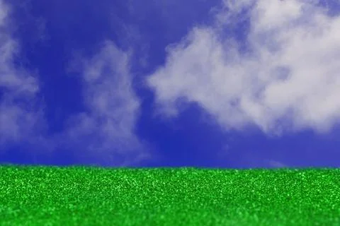 Grass on the sky background. Artificial turf, white clouds, green and blue te Stock Photos