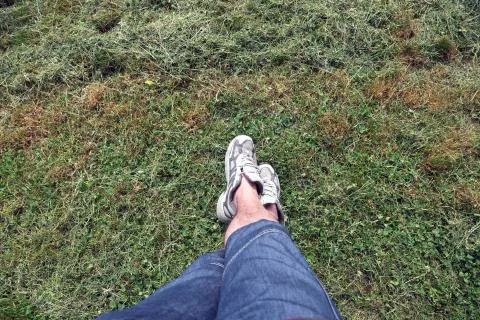 Grass texture with man in sneakers Stock-Fotos