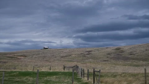 Grasslands, Storm clouds over small cabin and rangeland, 2k Stock Footage 153709800