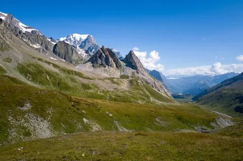 Grassy alpine slopes with dramatic rocky peaks Stock Photos