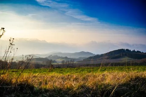 Grassy Field With Mountains in Background Stock Photos