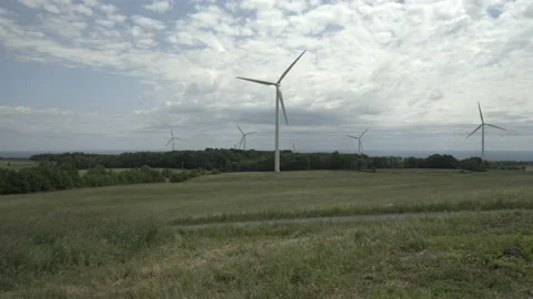 Grassy Field with a Wind Farm in the Background Stockbeeldmateriaal 197569376