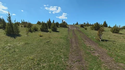 Grassy hill rises under clear blue sky. Balkan, Eastern Europe, POV Video stock 333442602
