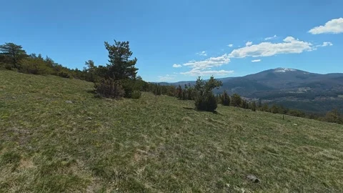 Grassy hill slopes gently under clear blue skies. Balkan, Eastern Europe, POV Vídeo Stock 333440556