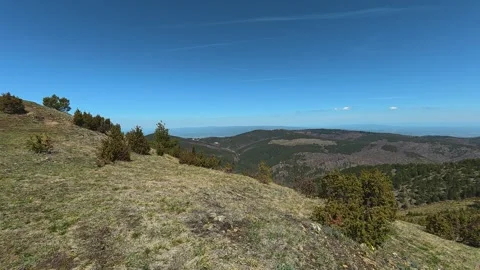 Grassy hillside under clear blue sky. Balkan, Eastern Europe, POV Vídeos de archivo 333440798