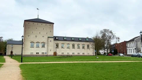 Grassy lawn fronts pale stone historic building square tower arched windows Stock Footage 327635512