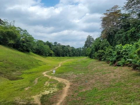 Grassy path winds through lush green landscape Stock Photos