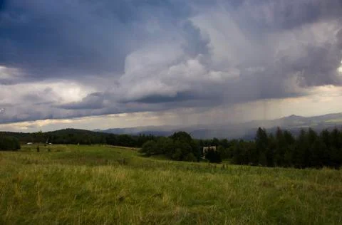 The grassy plain landscape with dramatic scenic sky with rain strands Stock Photos