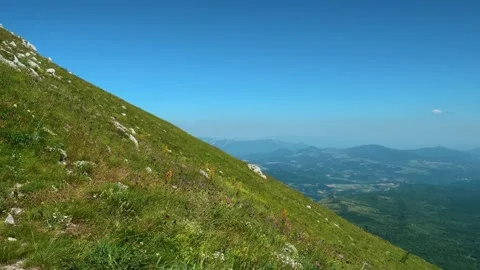Grassy slope slopes downward into distant hills. Mount Rtanj, Serbia Stockbeeldmateriaal 342314736