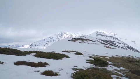Grassy slopes turn to snow covered mountain peaks in distance. Scenery of Video stock 247166158