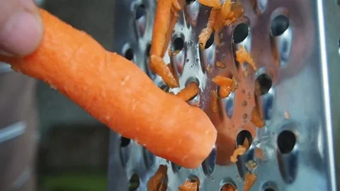 Grate carrot on a grater. Stock Footage 97381587