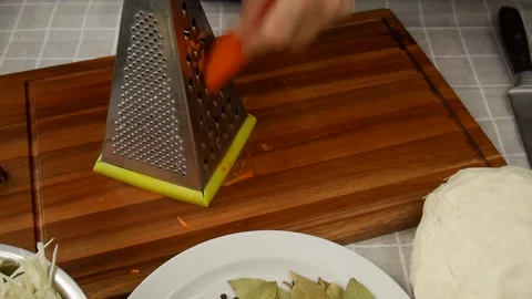Grate carrots in the kitchen. Video stock 238889261